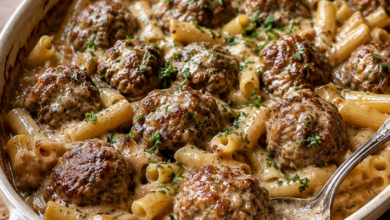 Swedish meatball noodle bake with browned meatballs, short pasta, creamy gravy, and fresh parsley in a casserole dish.