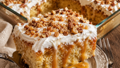 Ultra-moist homemade Toffee Butterscotch Poke Cake topped with whipped cream, chopped toffee bits, toasted pecans, and rich butterscotch sauce.