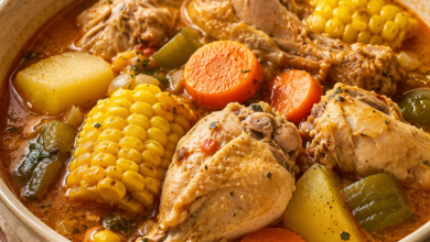 Homemade chicken souse with bone-in chicken, corn, potatoes, carrots and green bell pepper in seasoned broth.