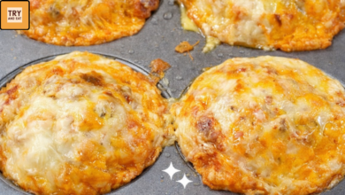 Cheesy breakfast crazy puffs baked in a muffin tin with eggs, sausage, and melted cheddar cheese