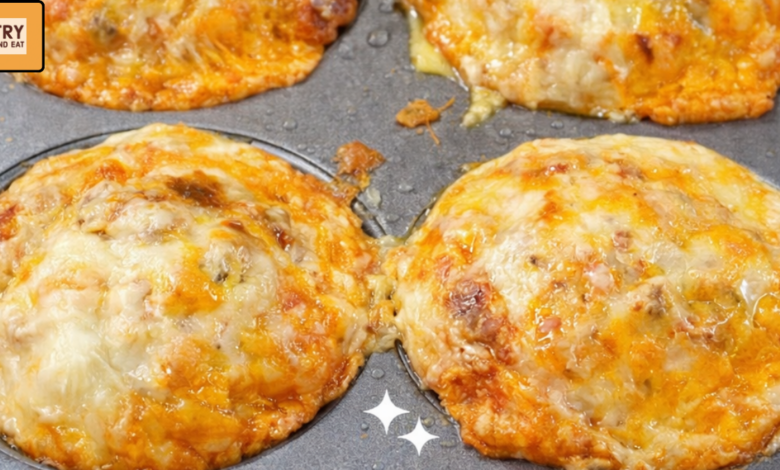 Cheesy breakfast crazy puffs baked in a muffin tin with eggs, sausage, and melted cheddar cheese