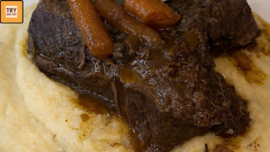 fall apart beef short ribs served over creamy garlic butter mashed potatoes with carrots and rich braising gravy