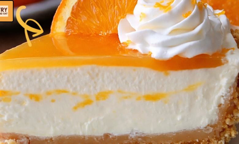 Slice of creamy orange creamsicle cheesecake with graham cracker crust topped with whipped cream and fresh orange slice