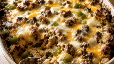 Philly cheesesteak casserole with browned beef, green peppers, onions, provolone, and melted cheddar cheese