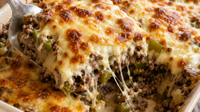 Philly cheesesteak casserole with ground beef, green peppers, onions, and browned melted cheese