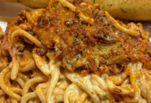 Cheesy baked spaghetti casserole with ground beef and creamy sauce