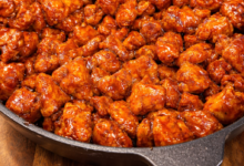 Crispy Korean chicken bites coated in sticky sweet spicy sauce in skillet