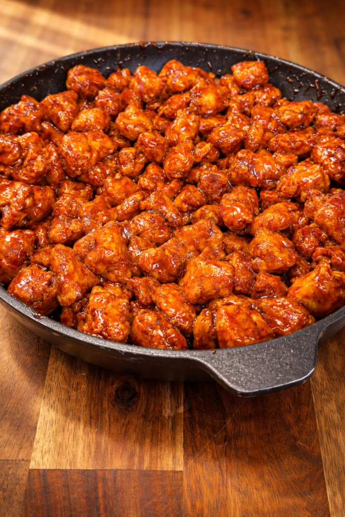 Crispy Korean chicken bites coated in sticky sweet spicy sauce in skillet