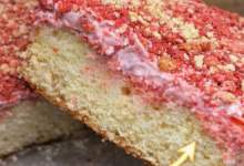slice of strawberry crunch cake showing soft layers and cream center