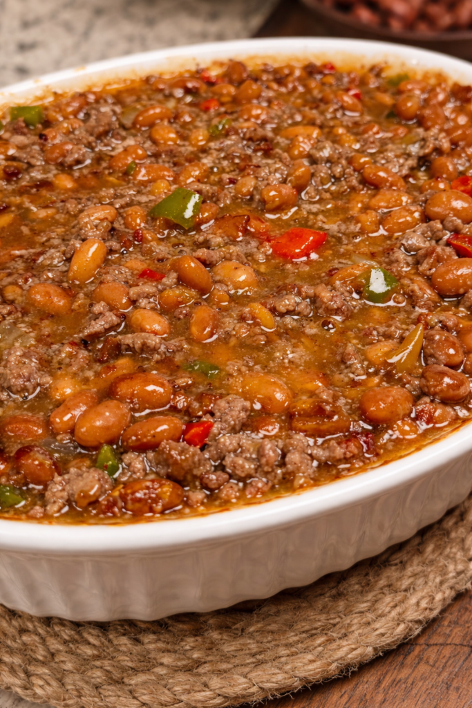 Loaded baked beans with ground beef in rich sauce baked in white dish