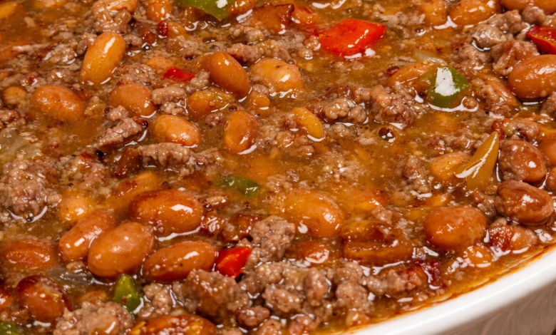 saucy loaded baked beans with ground beef in rich sauce baked in white dish