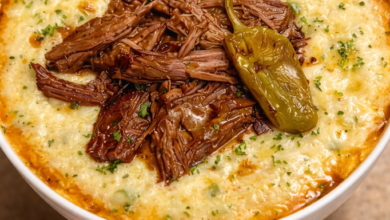Mississippi pot roast served over creamy cheesy grits with pepperoncini on top