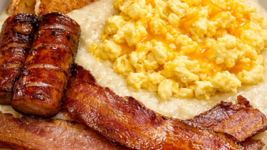 Creamy grits topped with scrambled eggs bacon sausage and toast Southern breakfast