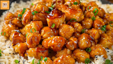 Sticky glazed chicken rice bowl with green onions and sauce drizzle