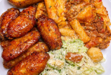 Sticky honey garlic chicken wings served with cheesy baked ziti, garlic bread, and creamy salad