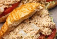 creamy tuna egg salad sandwich on croissant with lettuce and tomato