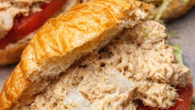 creamy tuna egg salad sandwich on croissant with lettuce and tomato