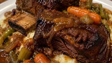 Braised beef short ribs served over creamy mashed potatoes with carrots, celery, and rich red wine gravy.