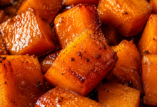 Close-up of brown sugar glazed sweet potato cubes caramelized in a buttery cinnamon glaze.