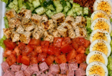Restaurant-style classic Cobb salad with grilled chicken, bacon, ham, cheddar cheese, eggs, cucumbers, tomatoes, and romaine lettuce.