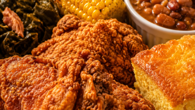Southern fried chicken dinner plate with cornbread, collard greens, baked beans, and corn on the cob