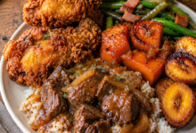 Southern soul food dinner featuring crispy buttermilk fried chicken, smothered beef tips over white rice, candied yams, caramelized plantains, and green beans with bacon on a rustic dinner plate.